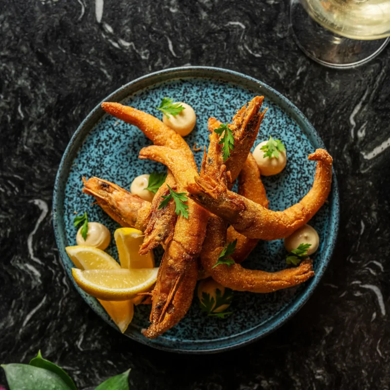 Camarões empanados no fubá crioulo com aioli (maionese de alho) e salsinha.
