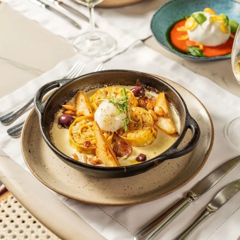 Rondelli de bacalhau com fonduta, pera, amêndoas, cebola caramelizada e ovo perfeito